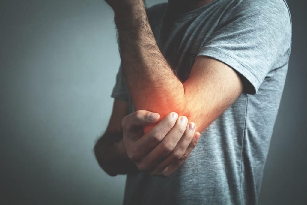 Man in pain holding his elbow