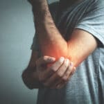 Man in pain holding his elbow