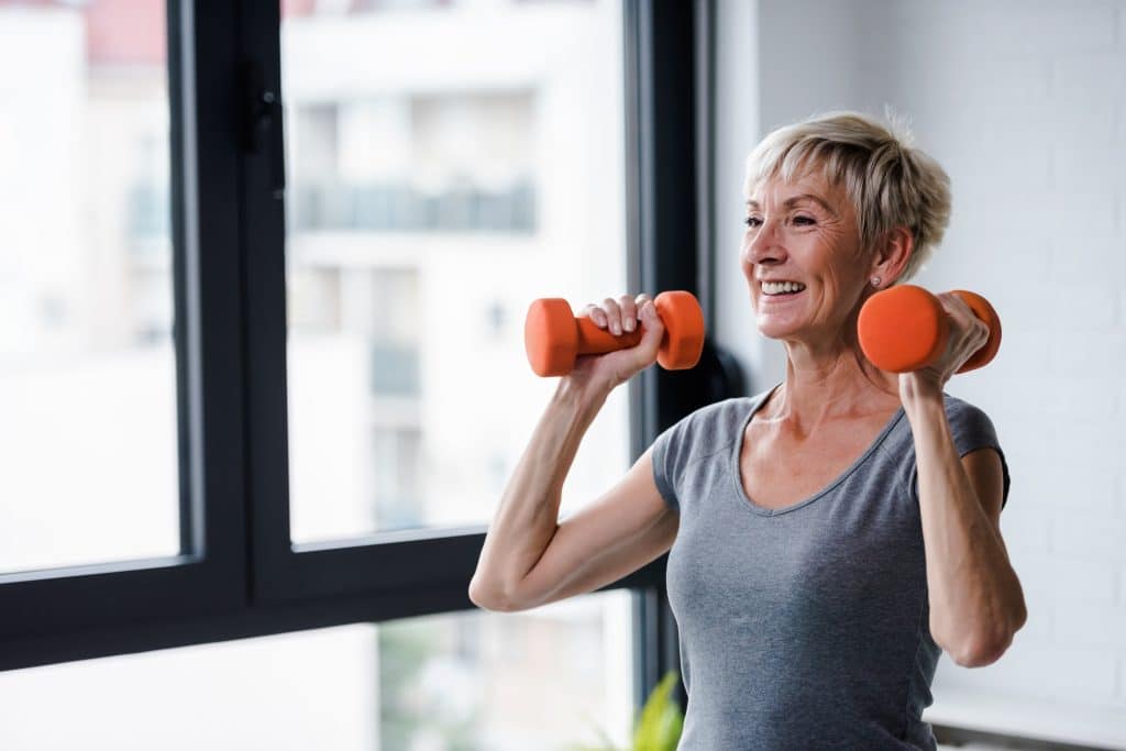 Portrait of senior woman lifting dumbbells