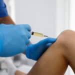 An orthopedic knee specialist administering an injection—a new treatment for osteoarthritis of the knee.