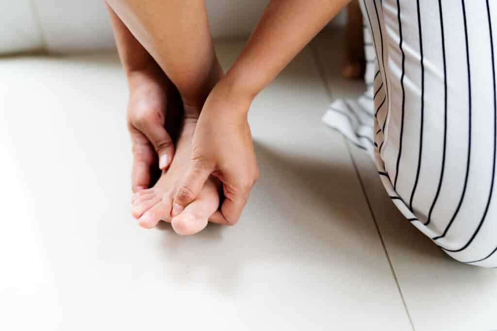 A person pulling their painful big toe to the side as a hallux rigidus exercise.